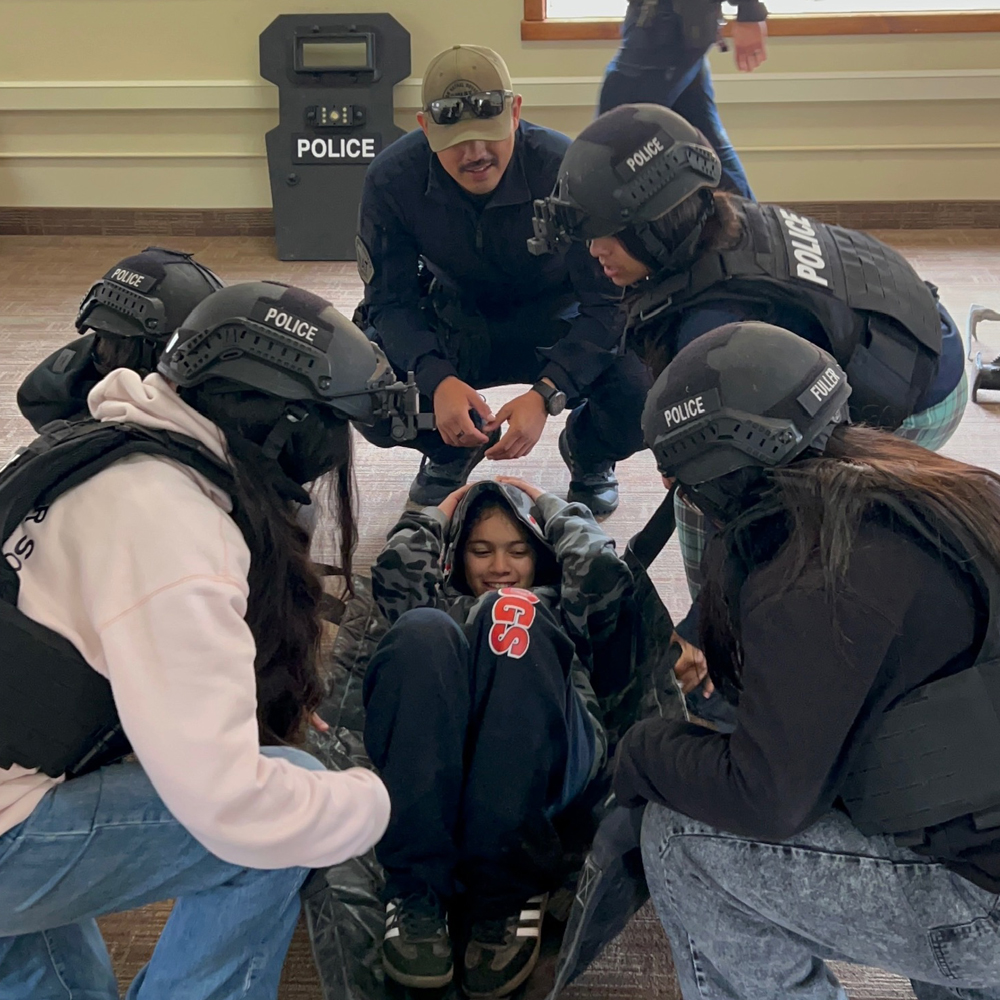 Search and rescue exercise, 4 campers putting one camper in a litter to carry her